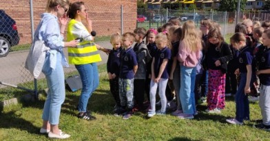 Na boisku szkolnym Inspektorzy Ochrony Środowiska mierzą poziom hałasu krzyczących dzieci.