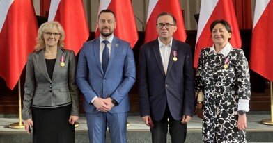 Odznaczeni Inspektorzy w obecności p.o. z-cy Łódzkiego Wojewódzkiego Inspektora Ochrony Środowiska w Łodzi na tle godła i flag państwowych