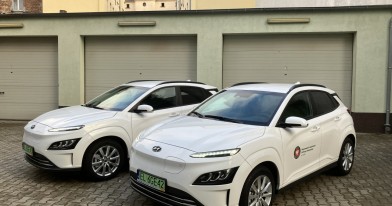 dwa auta elektryczne marki hyundai kona na tle garaży