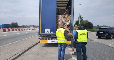 Inspektor Ochrony Środowiska z funkcjonariuszem Służby Celno - Skarbowej podczas czynności kontrolnych samochodu przewożącego odpady.