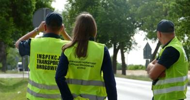 Inspektorzy i  funcjonaiusze stojący na wyznaczony punkcie kontrolnym